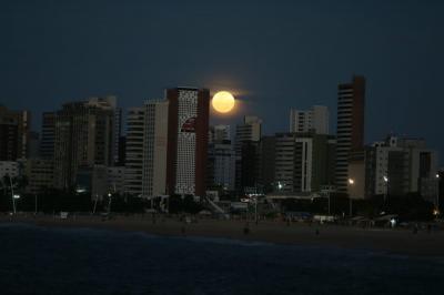 Lua cheia é vista com coloração alaranjada no céu de Fortaleza nesta sexta-feira
